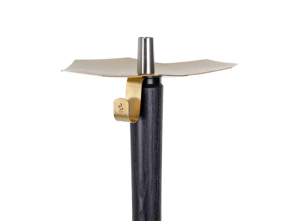 Modern hookah stem with gold metal tray and black wooden shaft against white background