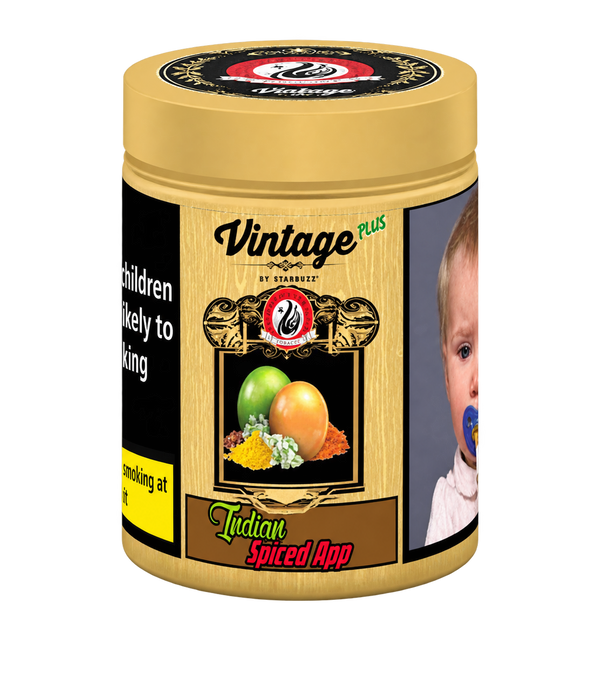 A cylindrical tin of Vintage Plus Indian Spiced App by Starvez, featuring a gold-colored lid and body with a wood-grain texture, a fruit illustration, and a warning label on the left side.