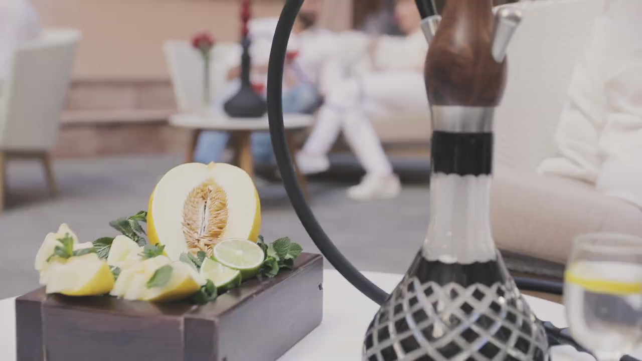 Woman enjoying Wookah shisha in elegant lounge environment with premium hookah and refined atmosphere